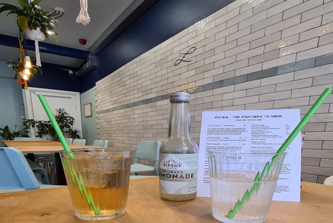 Close up of drinks bottle and lemonade in glasses.